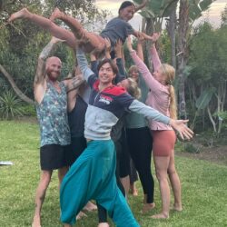 group of students lifting another student in the air in garden