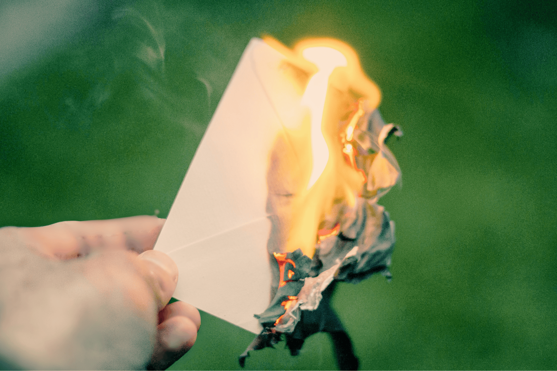 hand burning piece of paper