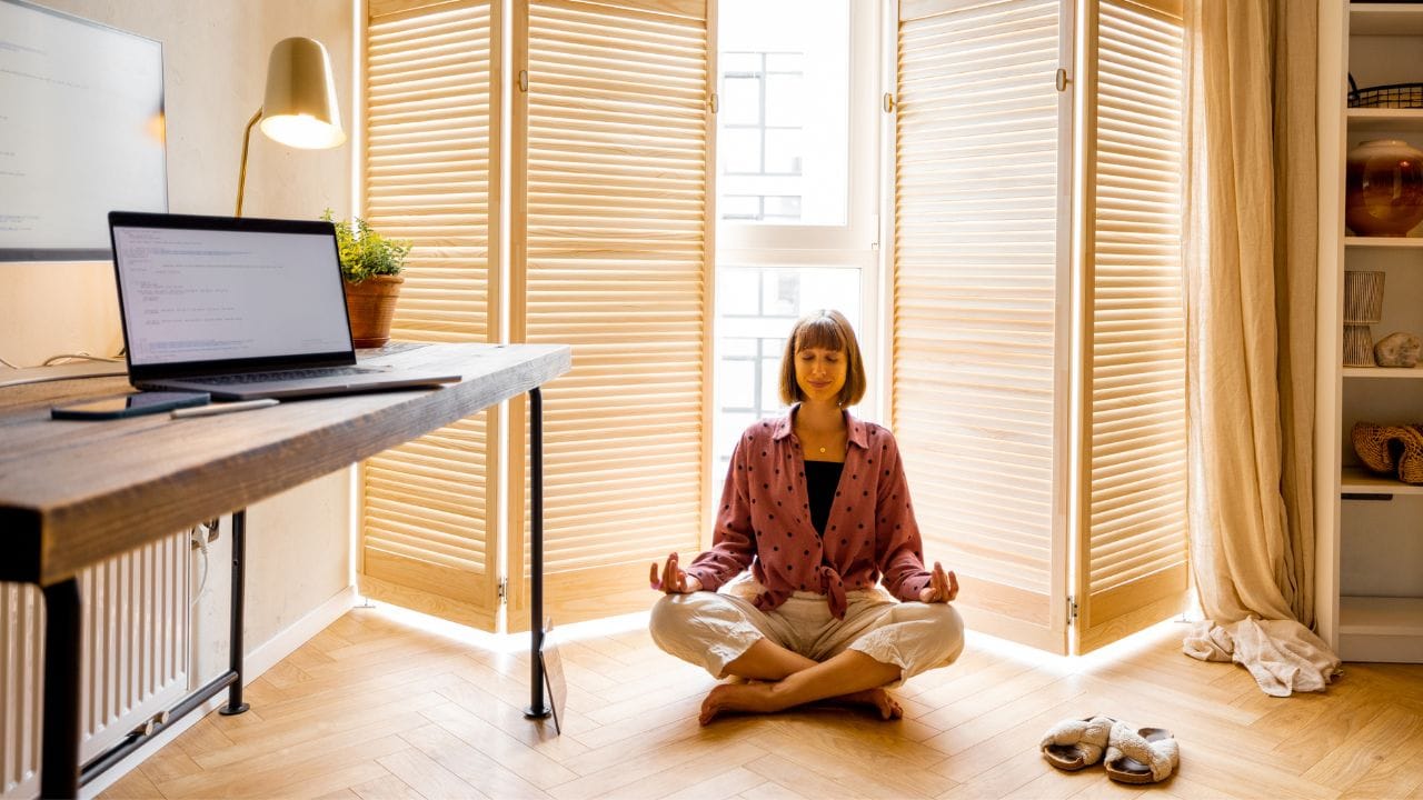 a woman sitting on floor at home doing Mantra Transcendental meditation technique