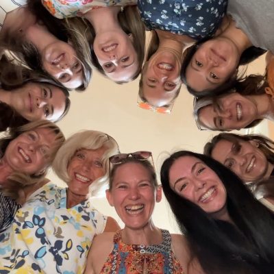 students in a circle looking down at camera