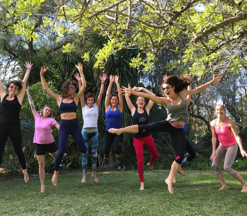yoga group jumping in air garden